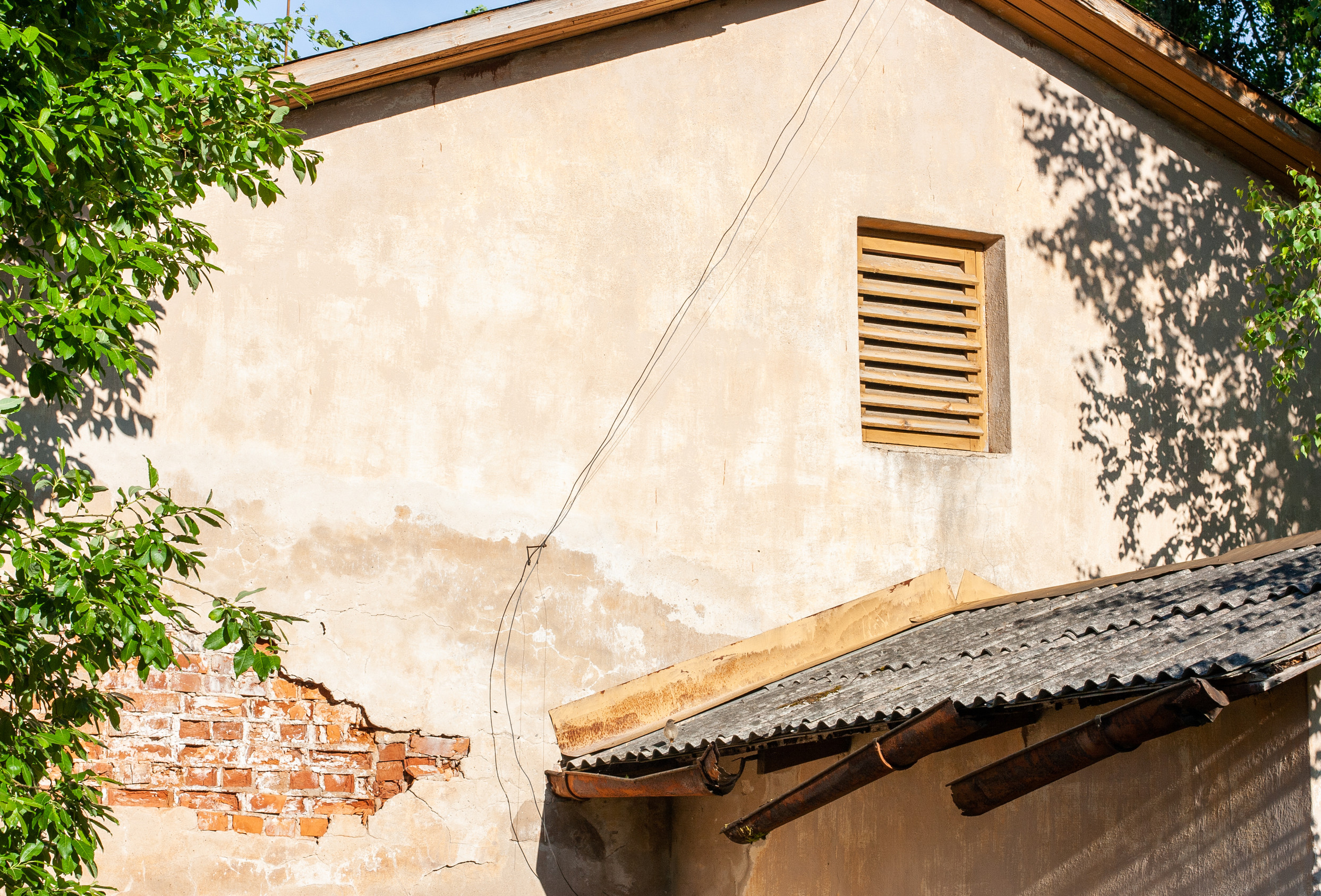 The wall of the house with a dilapidated plaster, with orange br